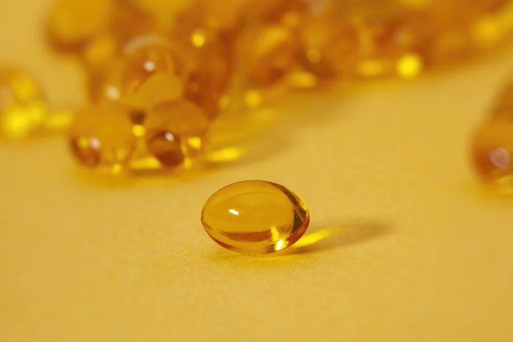 Vitamin D capsule held up toward the sun